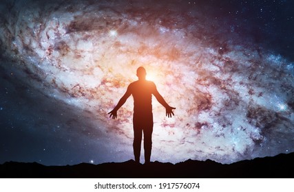 Silhouette of man stand on top of mountain and see in the night sky. Galaxy and space. Meditation and astrology. Esoterica and psychology. Elements of this image furnished by NASA