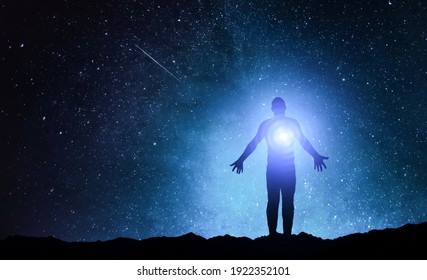 Silhouette of man stand and see in the night sky with stars. Galaxy and space. Light from the chest. Astrology sign. Esoterica and psychology. Elements of this image furnished by NASA
