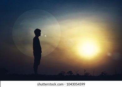 Silhouette of a man standing outdoors in light.