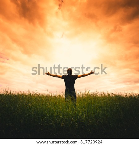 Silhouette of man and sunshine on sky background.