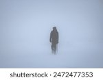 Silhouette of a man traveling in a snowstorm.
