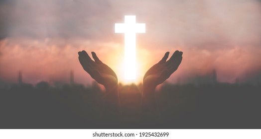 Silhouette a man use hand holding wooden cross with sunset backgrounds, religion concept, international prayer day.