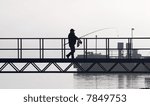 Silhouette of a man walking with fishing tackle