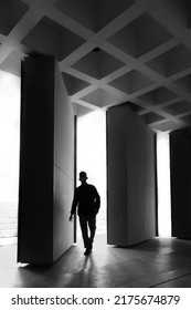 Silhouette Of Man Walking Through Door On White Light Background. Black And White Photography Concept