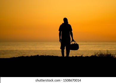 Silhouette Of A Man Wearing A Beanie And Holding A Duffle Bag Summer Travel Concept