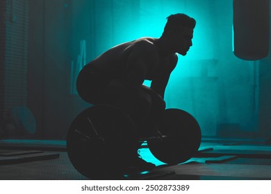 Silhouette, man and weightlifting with barbell for workout, exercise or training in fitness at gym. Active male person or bodybuilder lifting bar for muscle gain, strength or practice at health club - Powered by Shutterstock