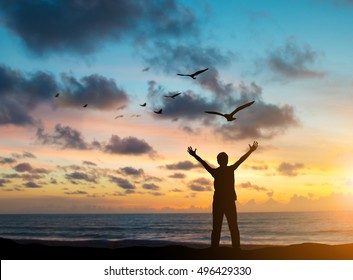 silhouette man were imprisoned on the island alone, praying and free bird fly over blurred nature sunset background. hope and people concept and international day of peace. - Shutterstock ID 496429330