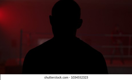 Silhouette of a man who comes into the room with a red light, back view. Shadow of man in the red room. Silhouette of a man in the light - Powered by Shutterstock