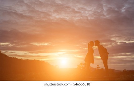 a silhouette of a man and woman holding hands with each other, walking together.