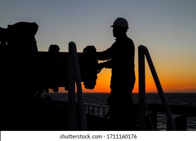 Silhouette Of Maritime Worker Making Inspection On Tanker Equipment On The High Seas, During The Sunset. Campos Basin, Brazil, August 2019.