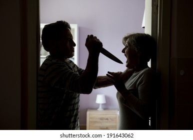 Silhouette of mature couple fighting, the man is attacking woman with knife. Woman is victim of domestic violence - Shutterstock ID 191643062