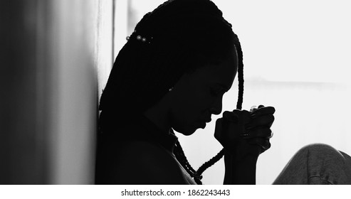 Silhouette meditative black woman praying during hard times