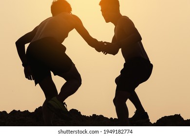 A Silhouette Of A Men Trail Runner Helping His Teammates To Cross Obstacles.