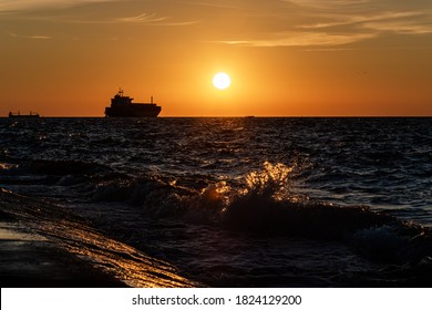 The Silhouette Of The Merchant Ship On The Horizon, Going Into The Sunset.