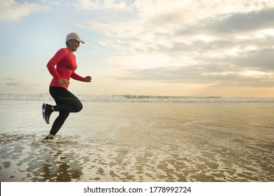 Silhouette Of Middle Aged Woman Running On The Beach - 40s Or 50s Attractive Mature Lady Doing Jogging Workout Enjoying Fitness And Healthy Lifestyle At Beautiful Sea Sunset Landscape