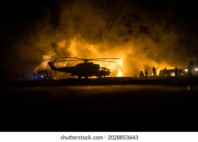 Silhouette of military helicopter ready to fly from conflict zone. Decorated night footage with helicopter starting in desert with foggy toned backlit. Selective focus. War concept
