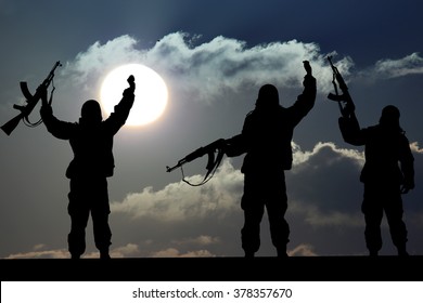 Silhouette of military soldier or officer with weapons at sunset. shot, holding gun, colorful sky, Concept of a terrorist. Silhouette terrorists with rifle at sunset