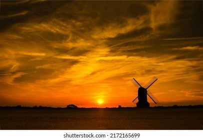 The silhouette of the mill at sunset. Windmill at sunset. Windmill sunset silhouette. Mill at sunset
