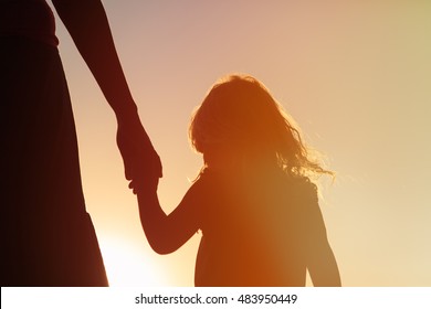 silhouette of mother and daughter holding hands at sunset - Powered by Shutterstock