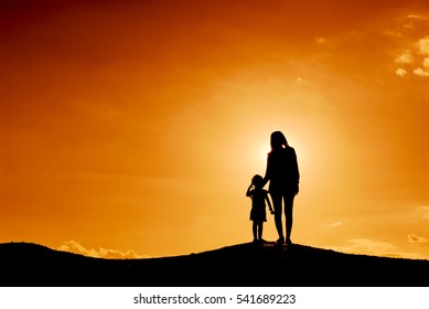 Silhouette Mother And Daughter At The Sky Sunset.