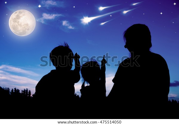お母さんと2人の子供が座って顔を上げ 彗星で空を見上げるシルエット カラフルな青い空と明るい満月の背景 友好的な家族 月はnasaが備え付けたものではない の写真素材 今すぐ編集