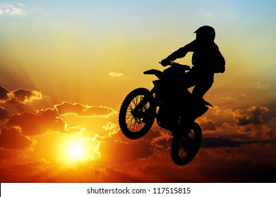 Silhouette of a motorcyclist on a background of dark sky