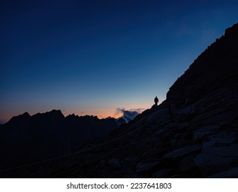Silhouette of a mountaineer tourist with a headlamp on a ridge during colorful sunset, fearless determination courage, Tatra mountains Slovakia Vysoke Tatry - Powered by Shutterstock