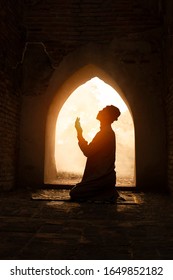 Silhouette Of Muslim Man Having Worship And Praying For Fasting And Eid Of Islam Culture In Old Mosque With Lighting And Smoke Background       