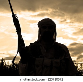Silhouette of muslim rebel with rifle