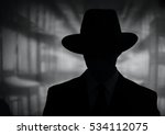 Silhouette of a mysterious man in a vintage style wide brimmed hat in a close up black and white head and shoulders portrait