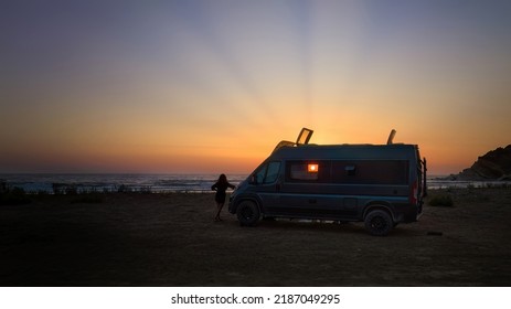 Silhouette of a offroad campervan   against the setting sun, the beach and the sea. Adventure of wild camping, nomadic life. Travelling in a van camper.  - Powered by Shutterstock