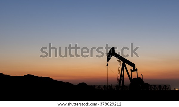 Silhouette of oil pump from\
oil field.
