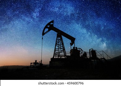 Silhouette of oil pump in the oil field in the night under Milky way