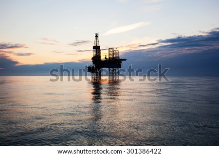 Silhouette of oil rig at sunset