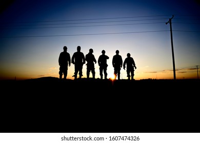 Silhouette Of Oilfield Workers At Sunset