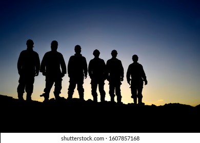 Silhouette Of Oilfield Workers At Sunset