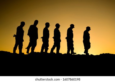 Silhouette Of Oilfield Workers At Sunset