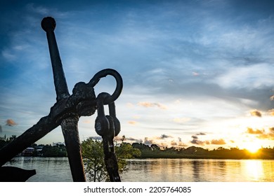 Silhouette Of Old Anchor In The Long Island Park And Sea Water Reflecting Morning Sunlight In Palau