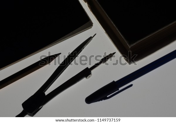 Silhouette of old opened book, exercise book, pen,\
divider, pencil for new education year. Elegant and creative photo\
for banner design or any other cool product which should stand out\
the crowd.