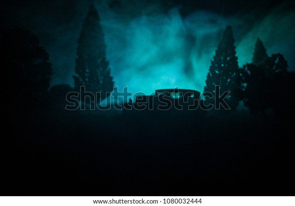 Silhouette of old vintage car in dark\
foggy toned background with glowing lights in low light, or\
silhouette of old car in dark forest. Selective\
focus