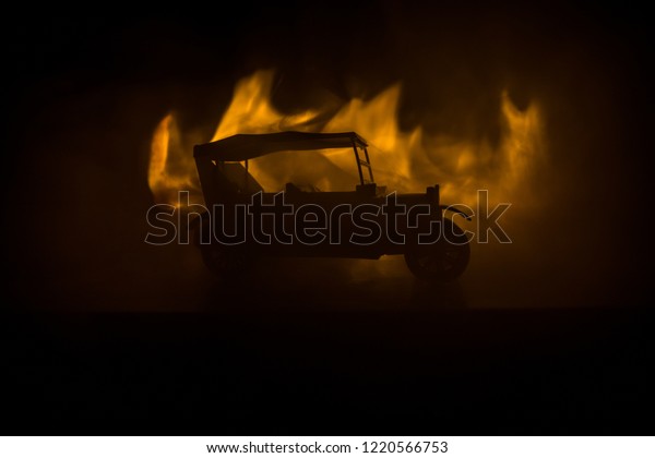 Silhouette of old\
vintage car in dark foggy toned background with glowing lights in\
low light. Selective\
focus