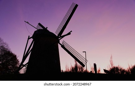 Silhouette of an old windmill that in previous centuries was used to make flour at dusk. It's made centuries ago by a Dutch builder and is located in Germany near the border with the Netherlands.