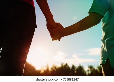 Silhouette Of Parent And Child Holding Hands At Sunset, Parenting