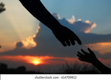 Silhouette Of  The Parent Holds The Hand Of A Small Child