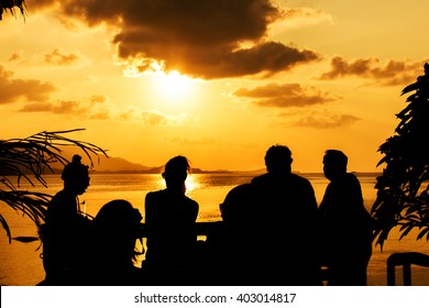 Silhouette of people at bar sunset background