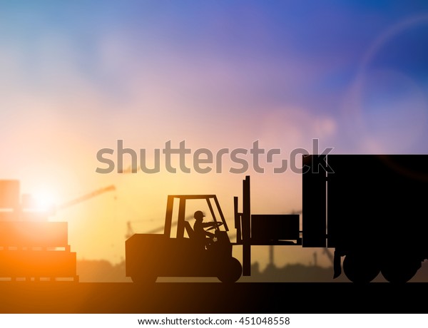 Silhouette People driver of the truck was put in\
the car to transport cargo to customers, securely over blurred\
pastel background sunset shipping. Heavy industry and\
Transportation and People\
concept.