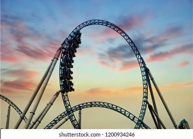 Silhouette of people having fun on a roller-coaster in an amusement park at sunset. Adrenalin concept. - Powered by Shutterstock