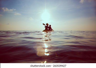 silhouette of people kayaking at sunset - Powered by Shutterstock