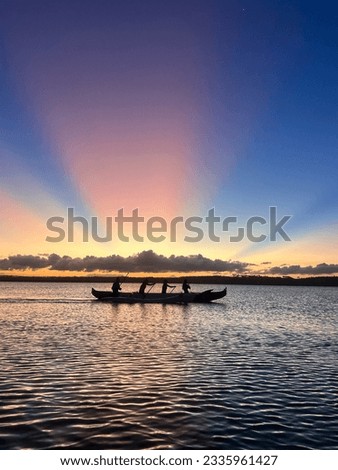 Silhouette of people practicing Hawaiian canoeing at Praia da Pipa in Rio Grande do Norte, Brazil.