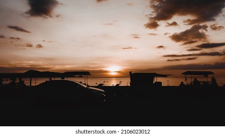 Silhouette People Standing Beach. Car Driving On Road. Landscape View Street Foods Night Market Evening Sunset . 